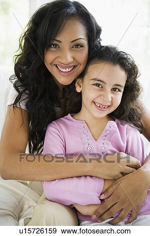 Mother and daughter in living room smiling (high key) View Large Photo Image Stock Photo - Mother and daughter in living room smiling (high key). Fotosearch