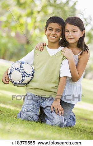 Two young children outdoors in park with ball smiling (selective focus) View Large Photo Image Stock Photography - Two young children outdoors in park with ball smiling (selective focus). Fotosearch