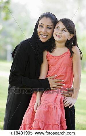 Woman and young girl outdoors in a park smiling (selective focus) View Large Photo Image Stock Photography - Woman and young girl outdoors in a park smiling (selective focus). Fotosearch
