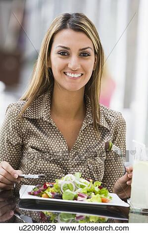 Woman at restaurant eating salad and smiling (selective focus) View Large Photo Image Stock Photo - Woman at restaurant eating salad and smiling (selective focus). Fotosearch