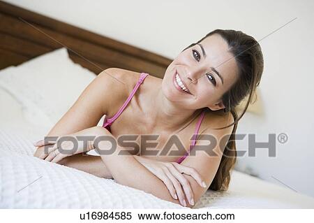 Woman relaxing on bed in bedroom smiling (selective focus) View Large Photo Image Stock Photography - Woman relaxing on bed in bedroom smiling (selective focus). Fotosearch