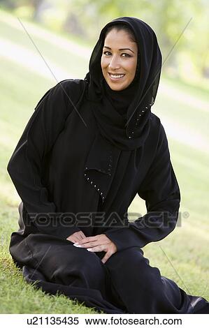Woman sitting outdoors in park smiling (selective focus) View Large Photo Image Stock Photography - Woman sitting outdoors in park smiling (selective focus). Fotosearch