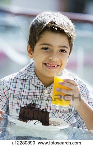Young boy at restaurant eating dessert and smiling (selective focus) View Large Photo Image Stock Image - Young boy at restaurant eating dessert and smiling (selective focus). Fotosearch