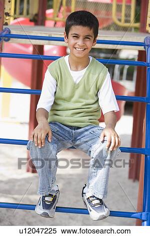 Young boy on playground structure smiling (selective focus) View Large Photo Image Stock Photography - Young boy on playground structure smiling (selective focus). Fotosearch