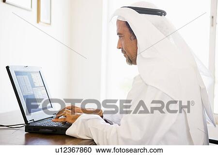 Man in office with laptop (high key/selective focus) View Large Photo Image Stock Image - Man in office with laptop (high key/selective focus). Fotosearch