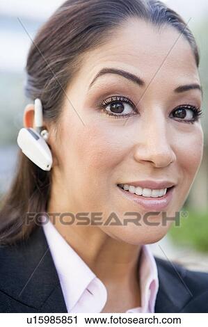 Woman wearing headset outdoors smiling (selective focus) View Large Photo Image Stock Image - Woman wearing headset outdoors smiling (selective focus). Fotosearch