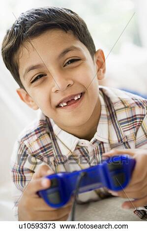 Young boy in living room playing video games and smiling (high key/selective focus) View Large Photo Image Stock Image - Young boy in living room playing video games and smiling (high key/selective focus). Fotosearch
