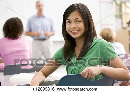 Female student with other students in classroom View Large Photo Image Stock Photograph - Female student with other students in classroom. Fotosearch