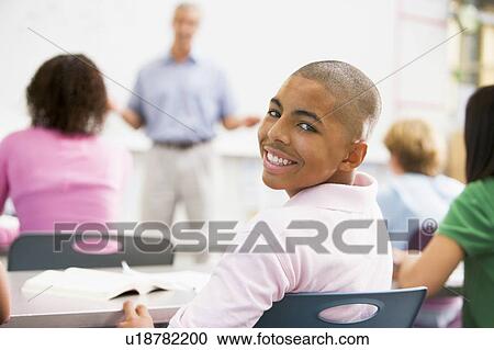 Male student with other students in classroom View Large Photo Image Stock Image - Male student with other students in classroom. Fotosearch