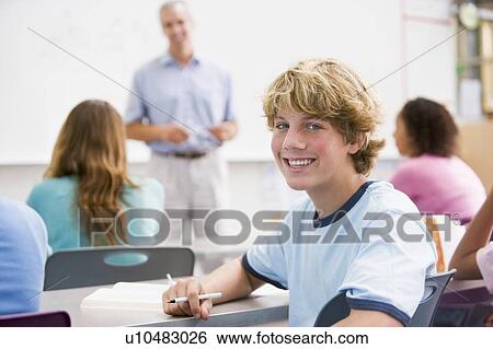 Stock Photograph - Male student with other students in classroom. Fotosearch
