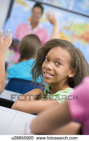Student in class looking at camera with teacher in background (selective focus) View Large Photo Image Stock Image - Student in class looking at camera with teacher in background (selective focus). Fotosearch