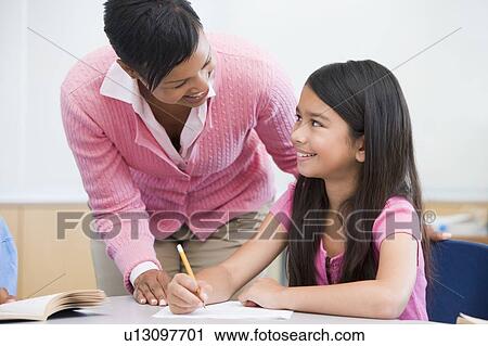 Student in class writing with teacher View Large Photo Image Stock Image - Student in class writing with teacher. Fotosearch
