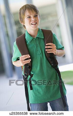 Stock Photo - Student standing outside school smiling (selective focus). Fotosearch