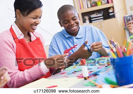 Stock Photo - Teacher and student in art class (selective focus). Fotosearch