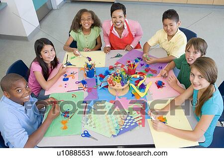 Stock Image - Teacher and students in art class. Fotosearch