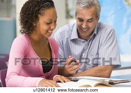 Teacher giving personal instruction to female student View Large Photo Image Stock Image - Teacher giving personal instruction to female student. Fotosearch