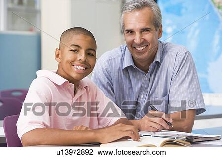 Stock Image - Teacher giving personal instruction to male student. Fotosearch