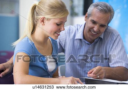 Stock Image - Teacher giving personal instruction to female student. Fotosearch