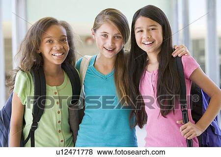 Stock Photo - Three students standing outside school together smiling (selective focus). Fotosearch