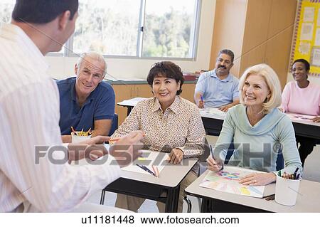 Adult students in class drawing pictures with teacher in foreground (selective focus) View Large Photo Image Stock Photo - Adult students in class drawing pictures with teacher in foreground (selective focus). Fotosearch