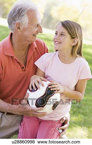 Grandfather and granddaughter outdoors with ball smiling View Large Photo Image Stock Photo - Grandfather and granddaughter outdoors with ball smiling. Fotosearch