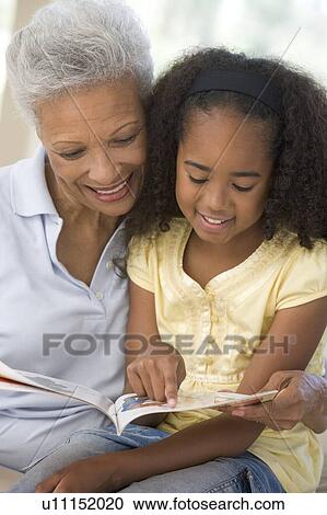 Grandmother and granddaughter reading and smiling View Large Photo Image Stock Image - Grandmother and granddaughter reading and smiling. Fotosearch