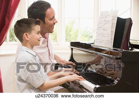 Man and young boy playing piano and smiling View Large Photo Image Stock Photograph - Man and young boy playing piano and smiling. Fotosearch