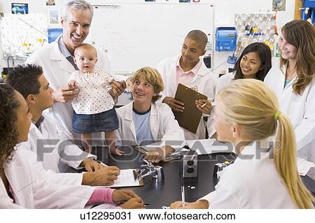 Stock Image - Students in biology class with teacher. Fotosearch