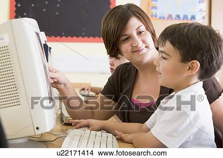 Students in class at computer terminals with teacher View Large Photo Image Picture - Students in class at computer terminals with teacher. Fotosearch