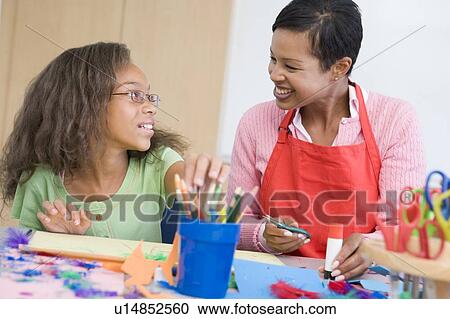 Stock Image - Teacher and student in art class (selective focus). Fotosearch