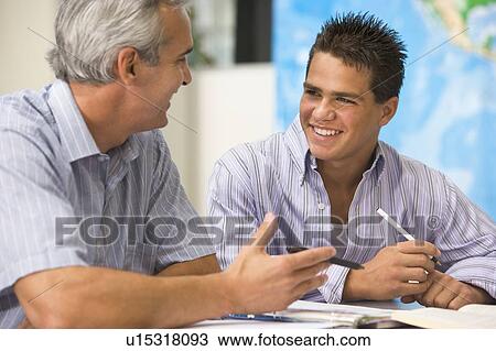 Stock Image - Teacher giving personal instruction to male student. Fotosearch