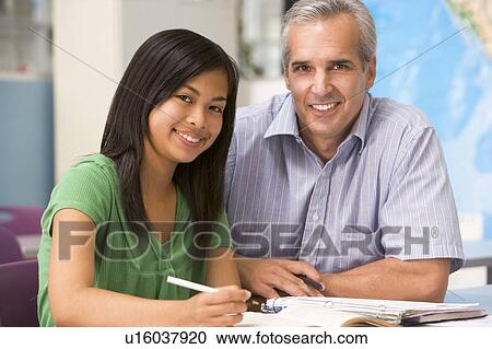 Stock Image - Teacher giving personal instruction to female student. Fotosearch