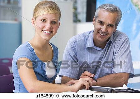 Teacher giving personal instruction to female student View Large Photo Image Stock Image - Teacher giving personal instruction to female student. Fotosearch