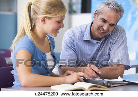 Stock Image - Teacher giving personal instruction to female student. Fotosearch