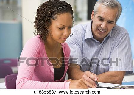 Stock Photo - Teacher giving personal instruction to female student. Fotosearch