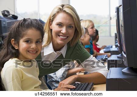 Teacher helping student at computer terminal with students in background (depth of field/high key) View Large Photo Image Stock Image - Teacher helping student at computer terminal with students in background (depth of field/high key). Fotosearch