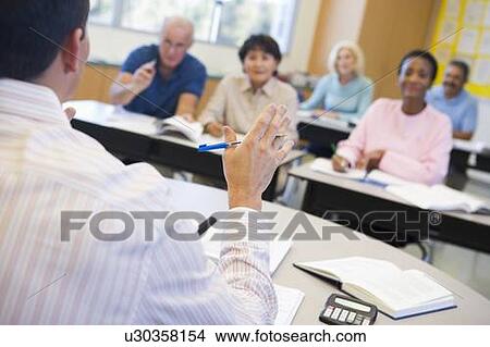 Picture - Teacher in class lecturing adult students (selective focus). Fotosearch