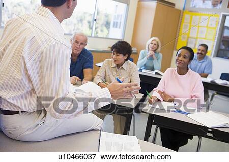 Teacher in class lecturing adult students (selective focus) View Large Photo Image Stock Photo - Teacher in class lecturing adult students (selective focus). Fotosearch