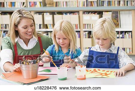 Stock Photograph - Two students in art class with teacher. Fotosearch
