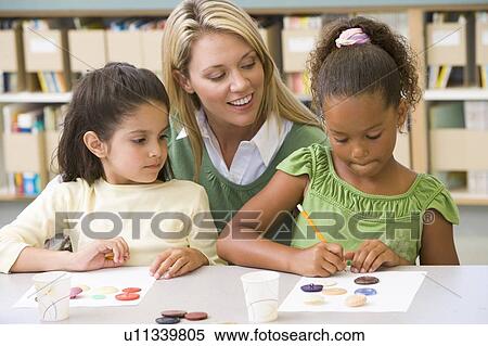 Stock Photography - Two students in art class with teacher. Fotosearch