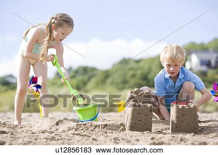 Brother and sister at beach making sand castles View Large Photo Image Stock Image - Brother and sister at beach making sand castles. Fotosearch