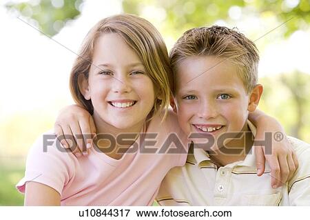 Brother and sister sitting outdoors smiling View Large Photo Image Stock Photo - Brother and sister sitting outdoors smiling. Fotosearch