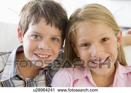 Brother And Sister Sitting Side By Side On A Couch View Large Photo Image Stock Image - Brother And Sister Sitting Side By Side On A Couch. Fotosearch