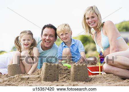 Family on beach making sand castles smiling View Large Photo Image Stock Image - Family on beach making sand castles smiling. Fotosearch
