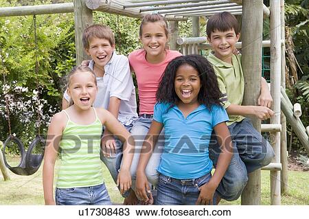 Stock Image - Five young friends at a playground smiling. Fotosearch
