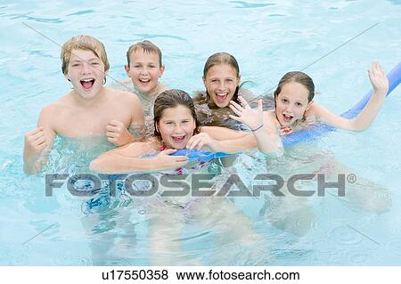 Stock Photo - Five young friends in swimming pool playing and smiling. Fotosearch