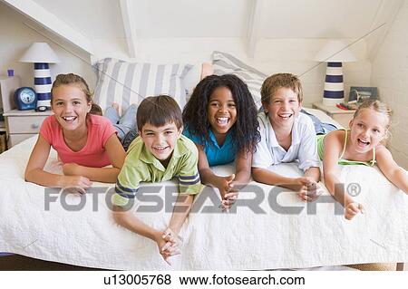 Stock Photo - Five Young Friends Lying Down Next To Each Other. Fotosearch