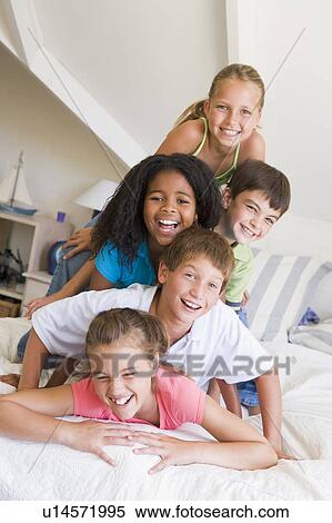 Stock Photography - Five Young Friends Lying On Top Of Each Other. Fotosearch