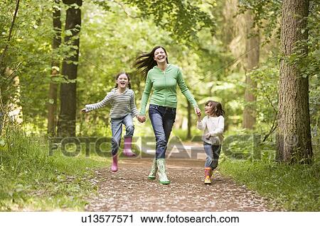 Mother and daughters skipping on path smiling View Large Photo Image Stock Image - Mother and daughters skipping on path smiling. Fotosearch