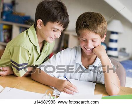Stock Image - Two Young Boys Doing Their Homework Together. Fotosearch